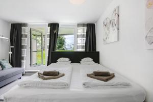 a white bedroom with two beds and a window at Ferienappartement Schmetterling in Sankt Englmar +22 photos