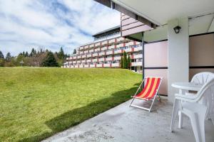 a red and white chair sitting on the porch of a building at Ferienappartement Schmetterling in Sankt Englmar