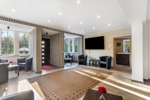 a lobby with chairs and a flat screen tv at Haus Fürstenberg Komplett in Fürstenberg