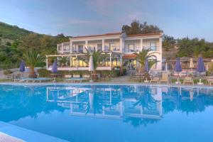 a hotel with a pool in front of a building at Karras Star Hotel in Evdilos