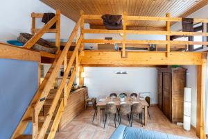 a room with a dining table and a loft bed at La maison d’Anthelmette in Valloire