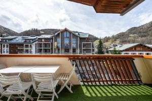 a balcony with a table and chairs on a balcony at La maison d’Anthelmette in Valloire