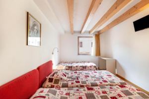 two twin beds in a room with red furniture at Apartment Latemar Casa Alma in Tesero