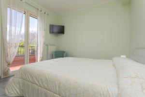 a bedroom with a bed and a balcony with a television at Villa Veronica in Mascali