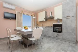 a kitchen with a table and chairs in a room at Villa Veronica in Mascali