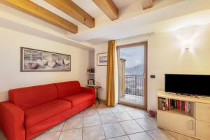 a living room with a red couch and a television at Apartment Latemar Casa Alma in Tesero