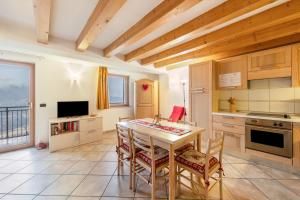 a kitchen with a table and chairs and a television at Apartment Latemar Casa Alma in Tesero