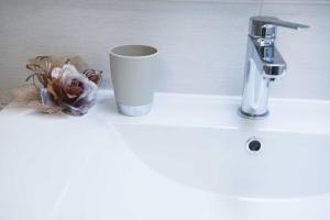 a cup sitting on a bathroom sink next to a faucet at B&B Solimo in Sulmona