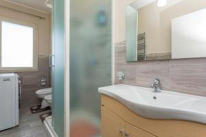 a bathroom with a sink and a mirror and a toilet at Villa Veronica in Mascali