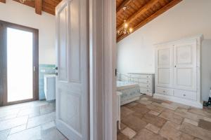 a white bathroom with a sink and a door at Villa Tramonto in Villasimius +19 photos