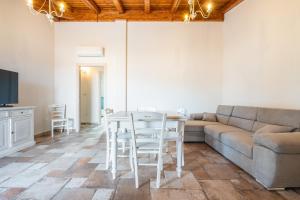 a living room with a couch and a table and chairs at Villa Tramonto in Villasimius