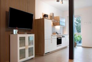 a kitchen with a flat screen tv on a wall at Kornblume in Unterwittighausen