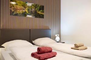 two beds with towels on them in a bedroom at Kornblume in Unterwittighausen