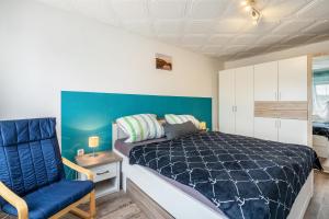 a bedroom with a bed and a blue wall at Familie Heiko Schroth in Neußen