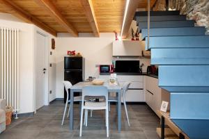 a kitchen with a table and chairs and a blue staircase at Chez Margot Et Sophie in Torgnon