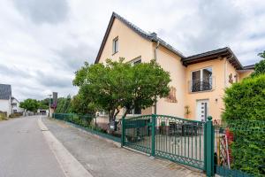 a house with a green fence on a street at Familie Heiko Schroth in Neußen