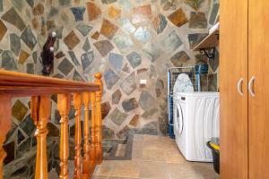 a stone walled bathroom with a washer and dryer at El patio canario in Firgas +22 photos