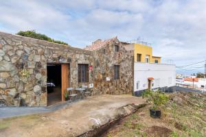 a stone building with a table outside of it at El patio canario in Firgas