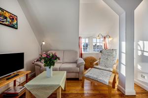 a living room with a couch and a tv at Haus Übersee Wohnung Tonga in Travemünde