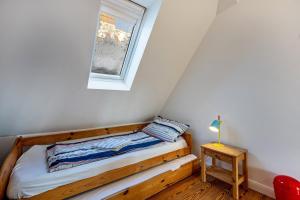 a small bedroom with a bed and a window at Haus Übersee Wohnung Tonga in Travemünde