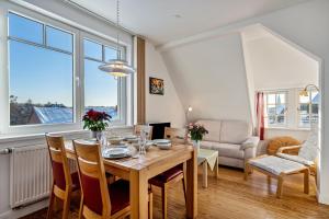 a dining room with a wooden table and chairs at Haus Übersee Wohnung Tonga in Travemünde