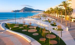a view of a resort with palm trees and the ocean at Altea Beach in Altea