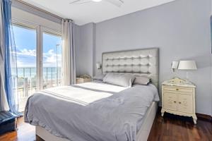 a white bedroom with a large bed and a window at Altea Beach in Altea