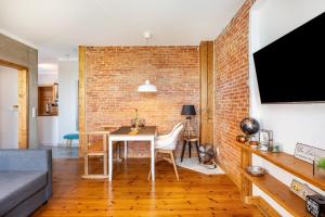a living room with a table and a brick wall at Koogbutze in Wesselburenerkoog