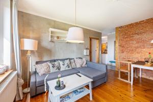a living room with a blue couch and a brick wall at Koogbutze in Wesselburenerkoog