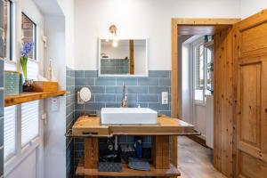 a bathroom with a white sink and blue tiles at Koogbutze in Wesselburenerkoog +18 photos