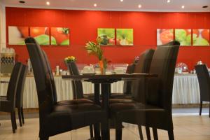 einen Tisch und Stühle in einem Restaurant mit roten Wänden in der Unterkunft Hotel Italia in München
