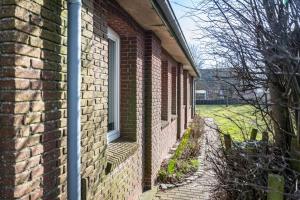 a brick building with a window on the side of it at Koogbutze in Wesselburenerkoog