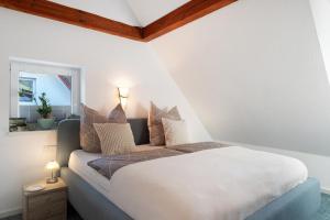 a bedroom with a bed with pillows and a window at Ferienwohnungen Steiert in Freiburg im Breisgau