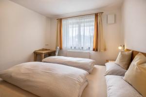 a bedroom with two beds and a window at Ciasa Silvia in San Martino in Badia