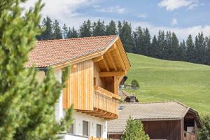 a house clad in wood with a roof at Ciasa Silvia in San Martino in Badia