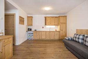 a living room with a couch and a kitchen at Ciasa Silvia in San Martino in Badia