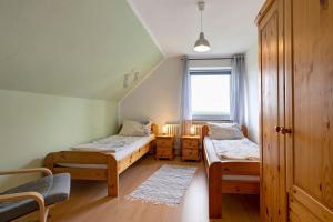 a small room with two beds and a window at Gästehaus Tadenswarf in Tadenswarf