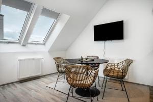 ein Zimmer mit Tisch, Stühlen und Flachbildfernseher in der Unterkunft Jever Auszeit in Jever