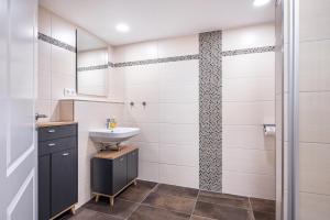 ein Badezimmer mit Waschbecken und Dusche in der Unterkunft Jever Auszeit in Jever + 29 Fotos