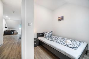 ein Schlafzimmer mit einem Bett in einem weißen Zimmer in der Unterkunft Jever Auszeit in Jever