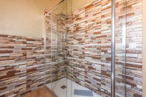 a bathroom with a glass shower with brick wall at Chabela's Penthouse in Lajita +19 photos