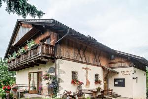 a building with a cross on the side of it at Zunerhof Studio Fenn in Longostagno