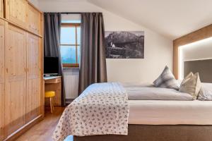 a bedroom with a bed with a desk and a window at Zunerhof Studio Fenn in Longostagno