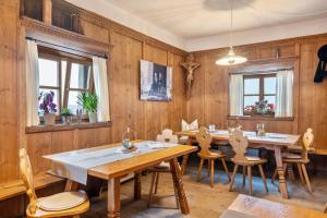 a dining room with wooden walls and tables and chairs at Zunerhof Studio Fenn in Longostagno