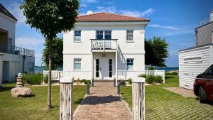 a white house with a walkway in front of it at Sliminde by Seeblick Ferien Oro in Kappeln