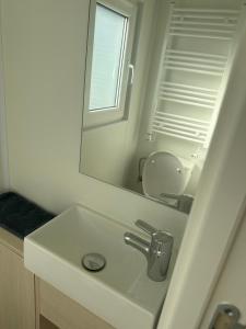a white bathroom with a sink and a mirror at Domaine 3016 in Roquebrune-sur-Argens +8 photos