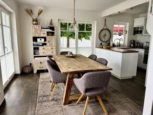 a kitchen with a wooden table and chairs at Sliminde by Seeblick Ferien Oro in Kappeln
