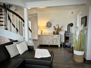 a living room with a black couch and a fireplace at Sliminde by Seeblick Ferien Oro in Kappeln