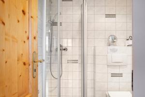 a shower with a glass door in a bathroom at Rathäusle in Titisee-Neustadt +49 photos