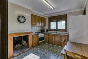 a kitchen with a fireplace and a clock on the wall at Can Picola in Capmany